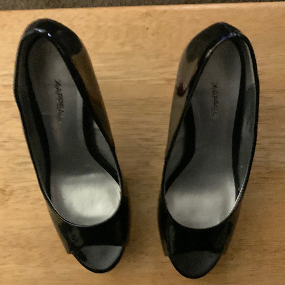 Black plate form shoes with orange heels at the toe orange and a hint of pink.